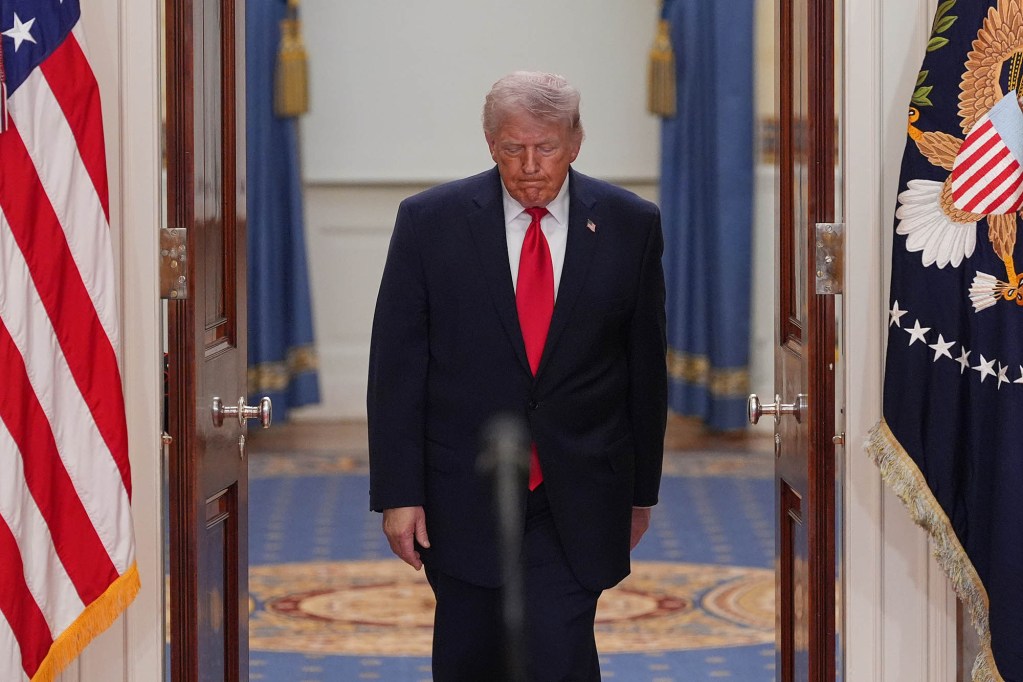 Donald Trump walking in the White House toward a microphone.