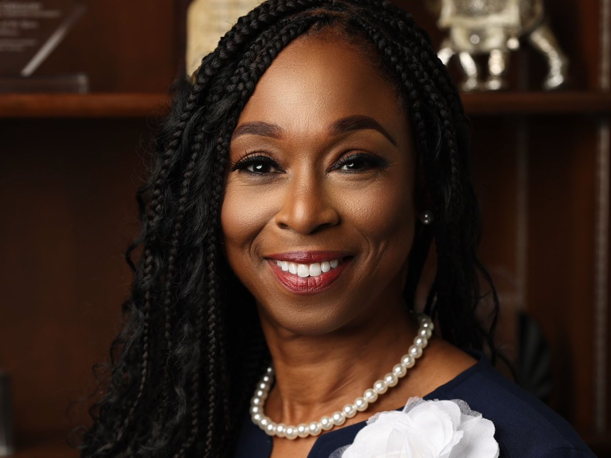 Dr. Denise Jones Gregory in a navy top and white pearl necklace