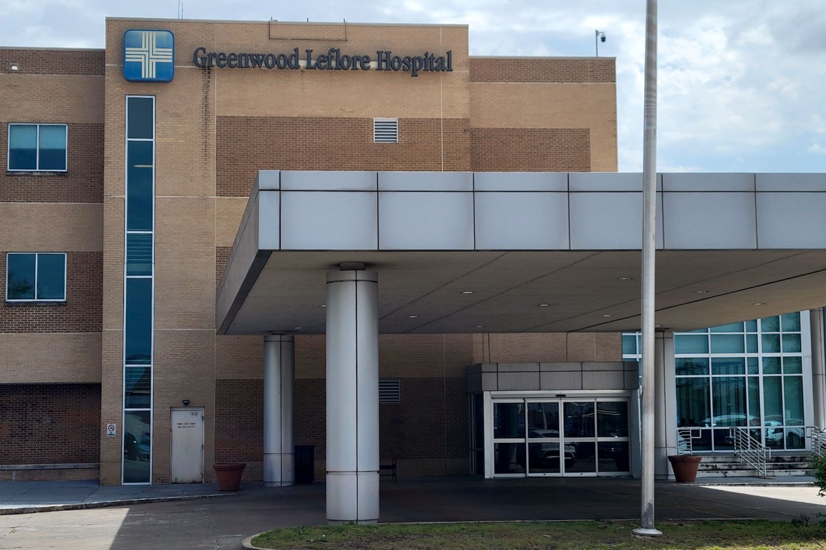 A light brown brick building labeled Greenwood Leflore Hospital