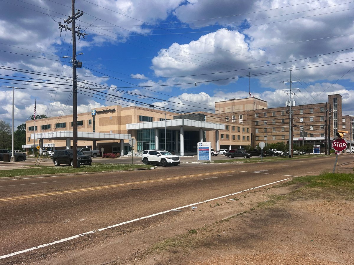 a hospital with cars in the parking lot