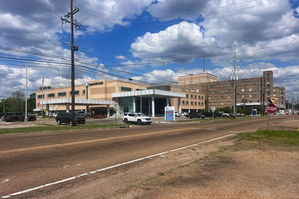 a hospital with cars in the parking lot