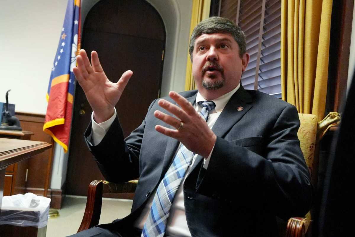 Jeremy England, seated in an office and speaking while gesturing his hands