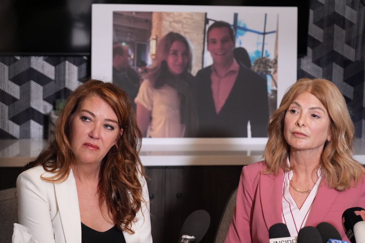 Lonna Drewes and her lawyer speak in front of a row of microphones at a press event