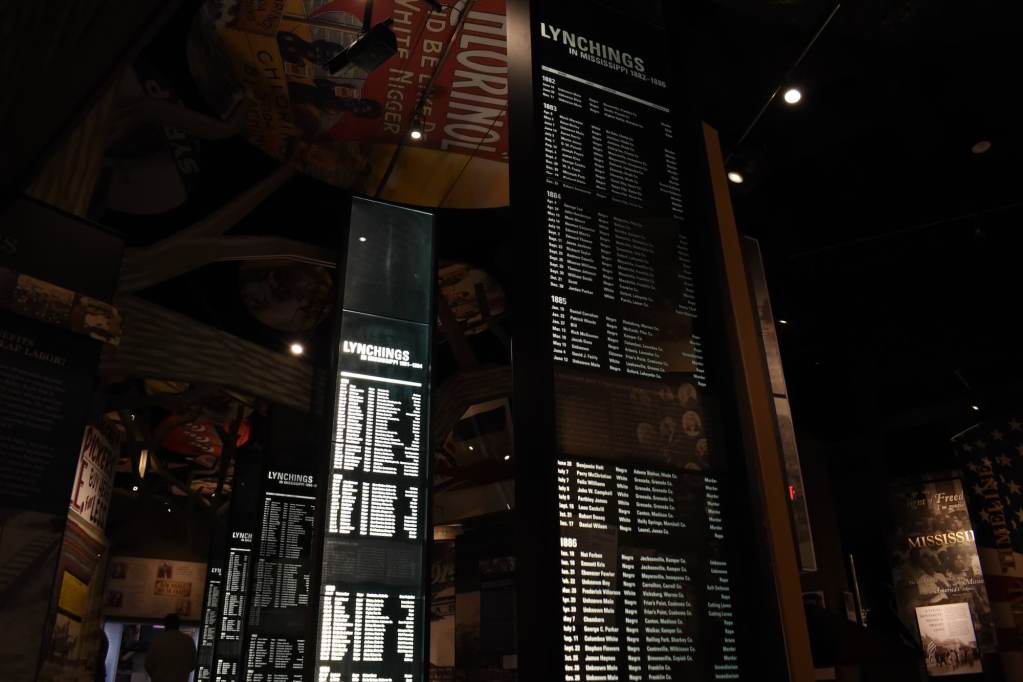 Video boards with displays titled “Lynchings in Mississippi” with lists of names.