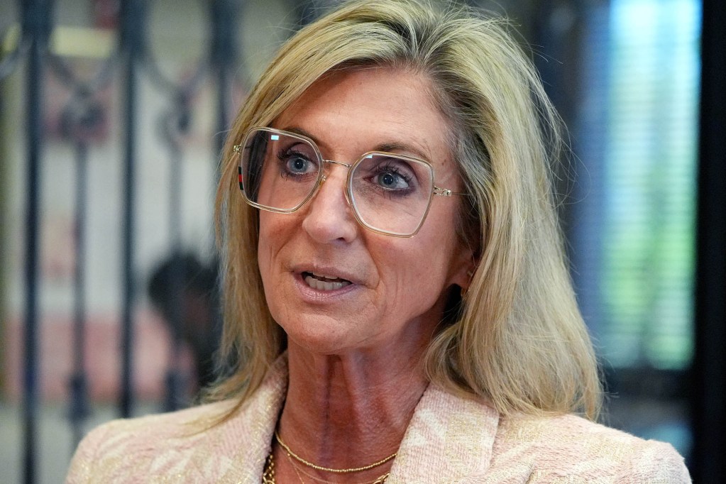 A closeup of Robyn Tannehill, in pale colors, speaking