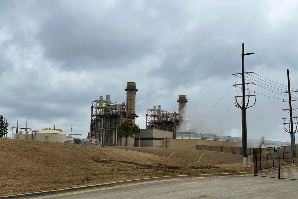 A view of a power plant from the road on a cloudy day