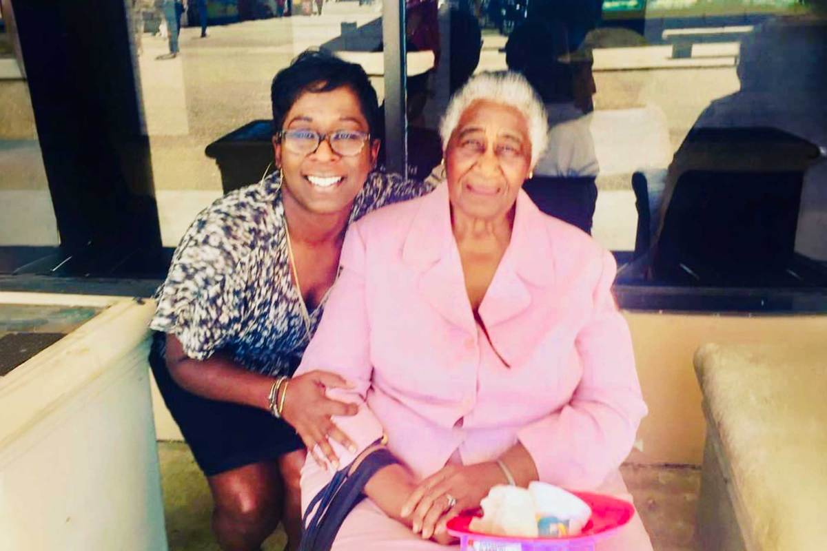 Tami Jones kneels beside her grandmother, seated