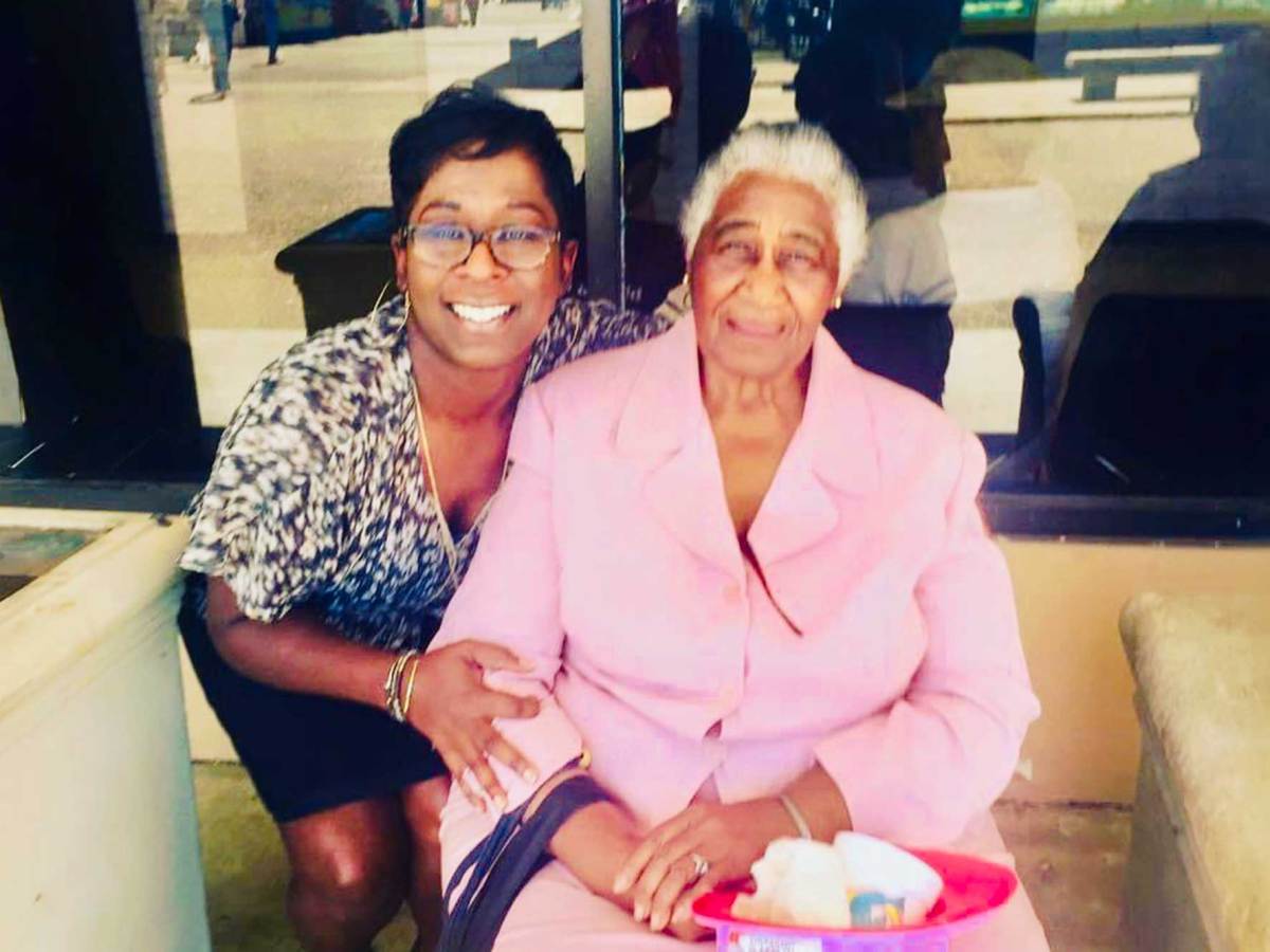 Tami Jones kneels beside her grandmother, seated