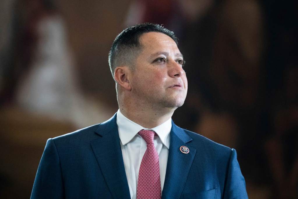 A closeup of Tony Gonzales in a suit, speaking at an event