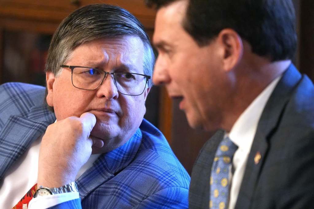 Dan Edney leans in, chin in hand, listening to Lee Yancey talk at a meeting