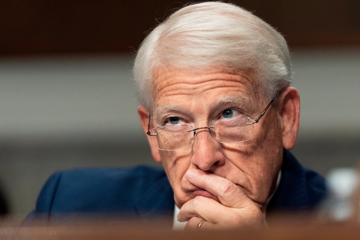 Roger Wicker with his fingers over his mouth, listening intently