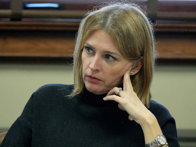 Shanda Yates sits at a table with one hand propped on her face.