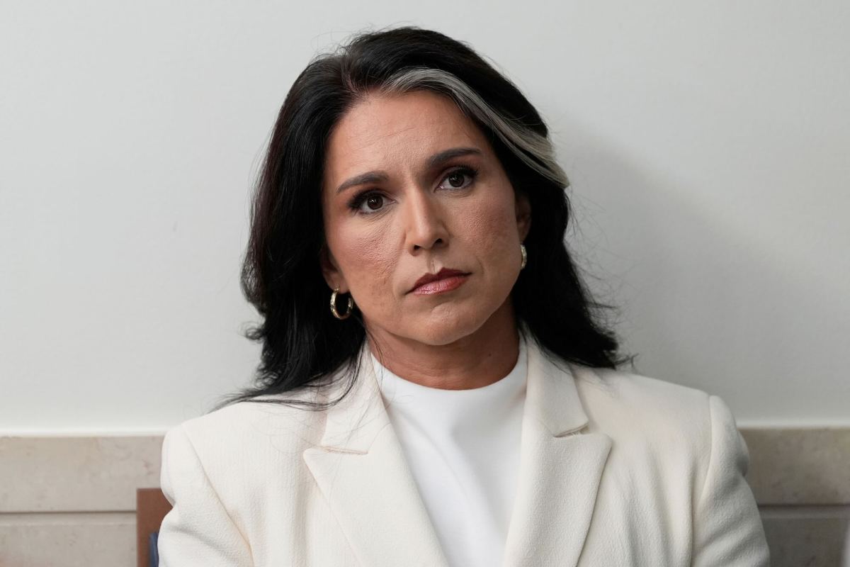 A close up photo of Tulsi Gabbard, wearing a white suit