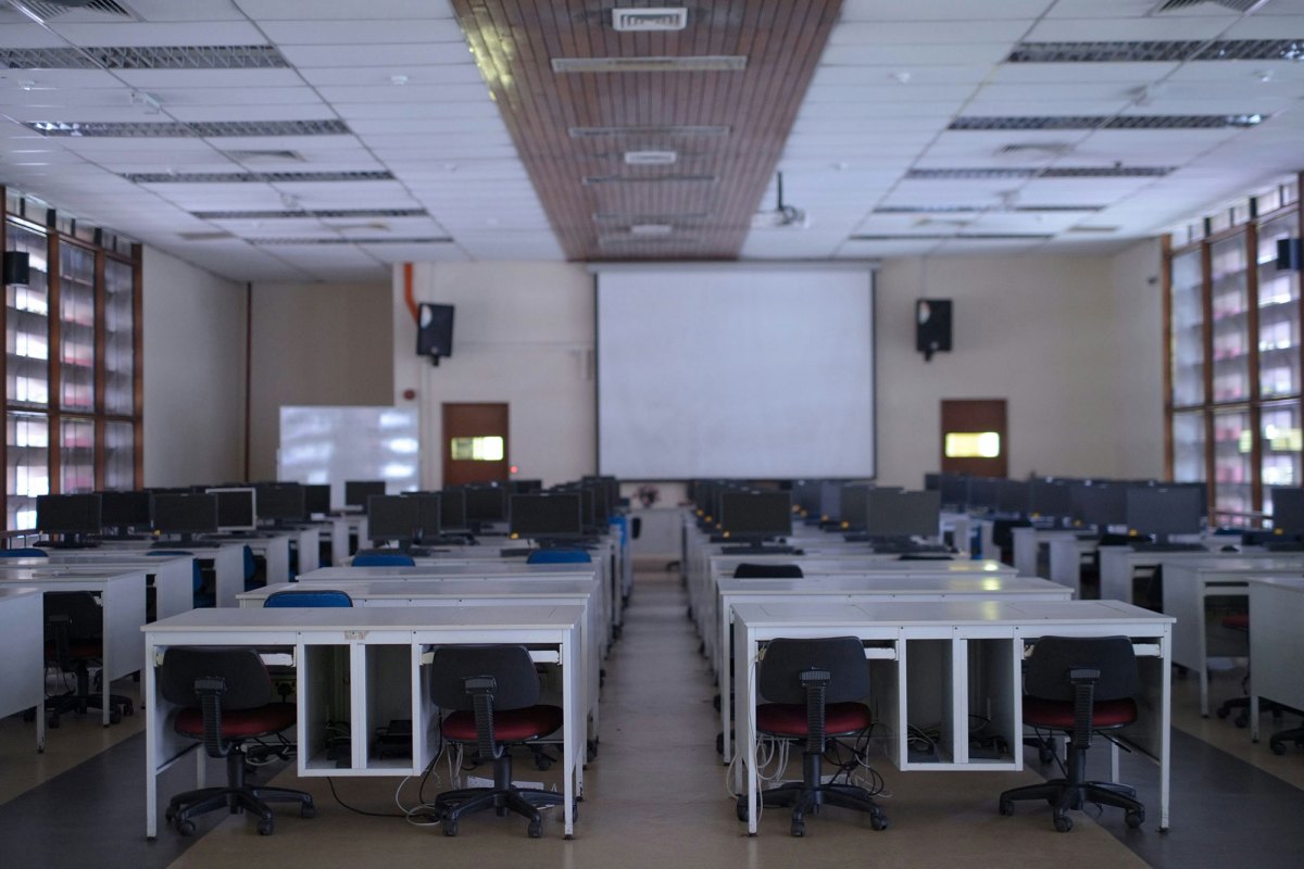 An empty classroom with rows of chairs, desks and computers