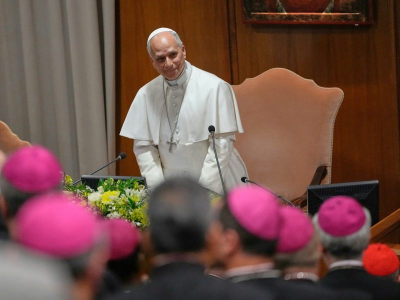 Pope Leo XIV standing in front of a large chair at a meeting