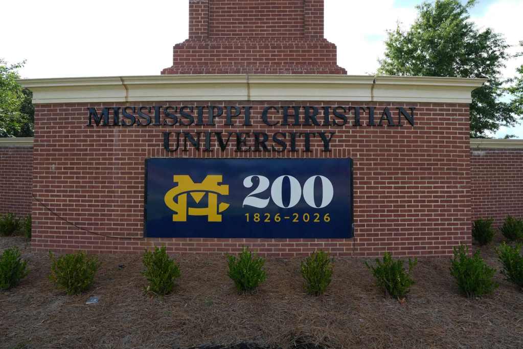 A brick display with black letters displaying “Mississippi Christian University.” Below it is a sign with the Mississippi College logo and “200 1826-2026.”
