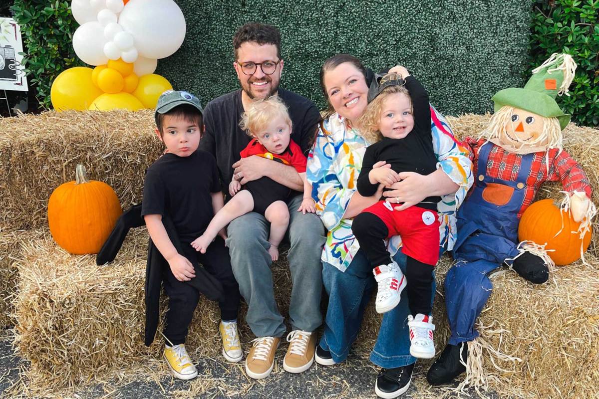 Parents pose with their three children in a fall harvest display
