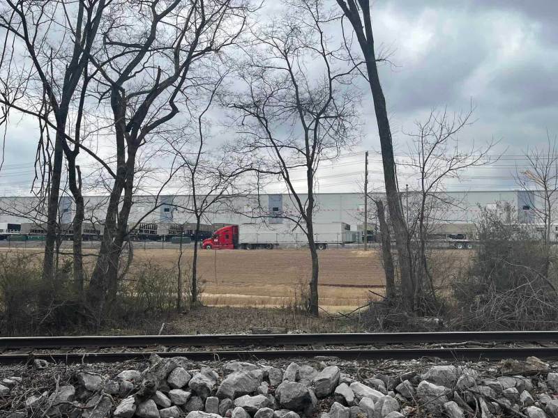 A data center can be seen past a railroad track and some trees