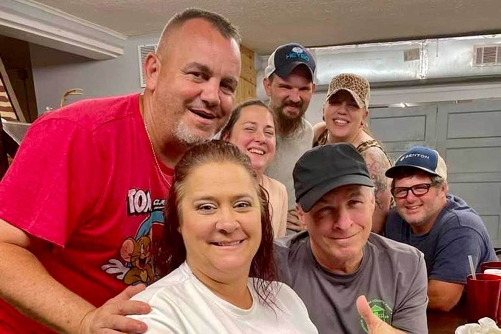 Seven people stand together inside for a photo
