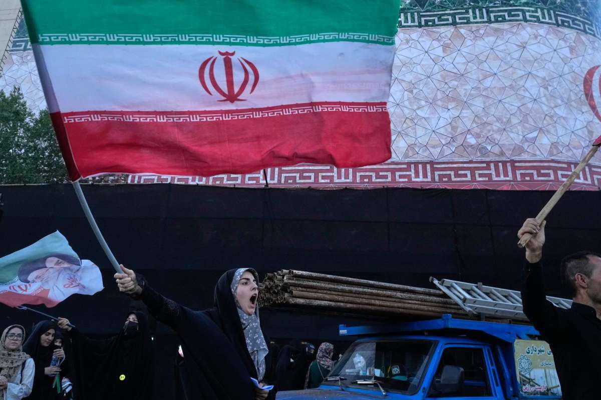 A woman waving an Iranian flag outside