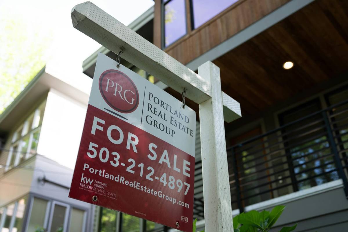 A “For Sale” sign by Portland Real Estate Group in front of a house.